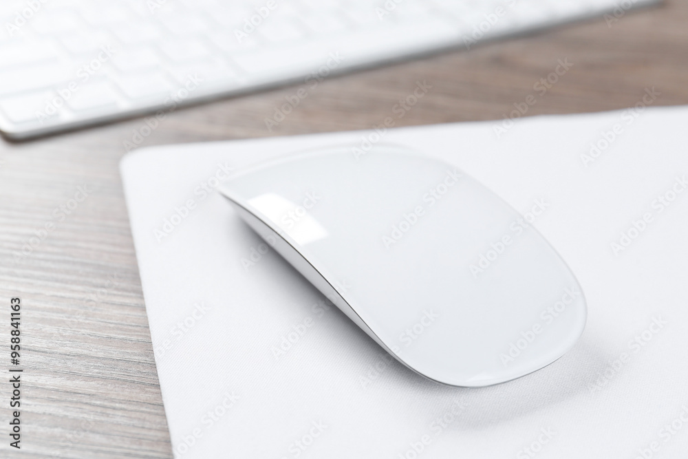 Computer mouse with mousepad and keyboard on wooden desk, closeup Computer mouse with mousepad and keyboard on wooden desk, closeup