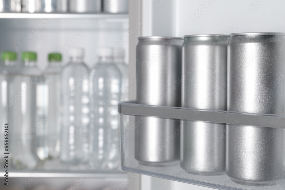 Cans of beer and water bottles in refrigerator, closeup Cans of beer and water bottles in refrigerator, closeup