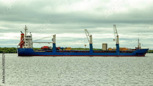 A large cargo sea vessel is at anchor, a dry cargo ship is at anchor