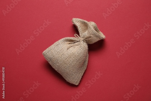 One burlap sack on red background, top view