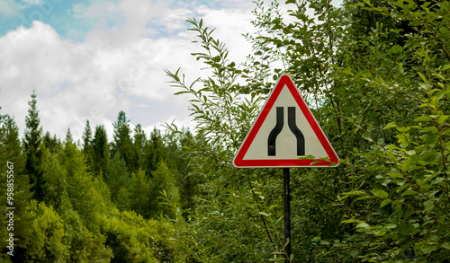 road signs warning of narrowing of the road, on a dirt road