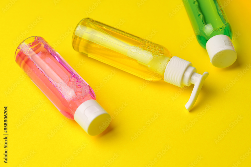 Colorful Bottles of Liquid Soap on Yellow Background Colorful Bottles of Liquid Soap on Yellow Background