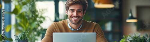 A man is sitting at a desk with a laptop in front of him photo