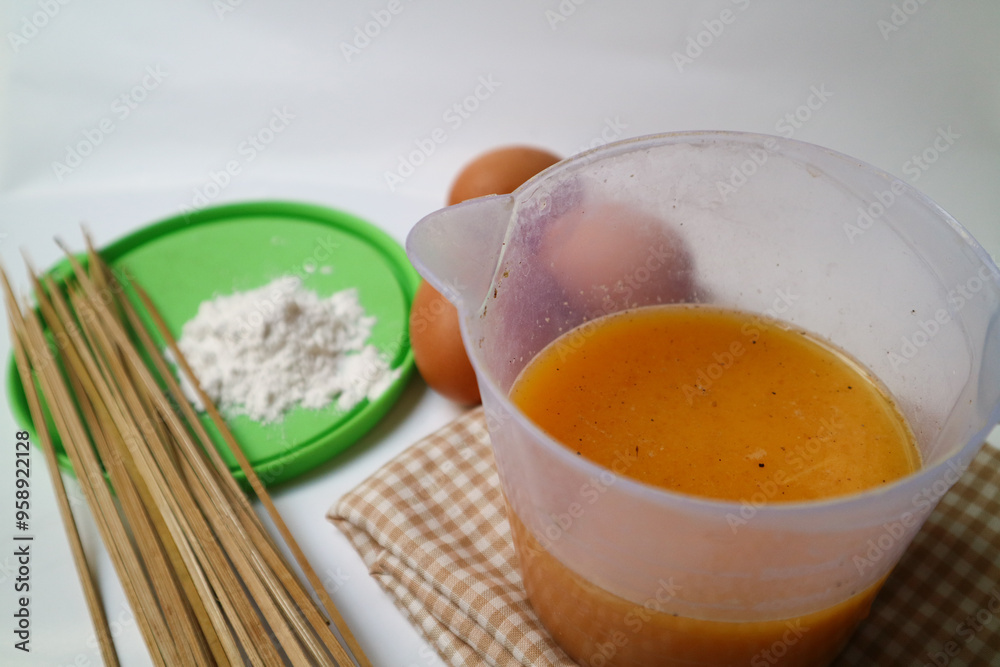 preparation for making egg rolls or telur gulung, using eggs mixed with flour and pepper. And pierced using a skewer. preparation for making egg rolls or telur gulung, using eggs mixed with flour and pepper. And pierced using a skewer.