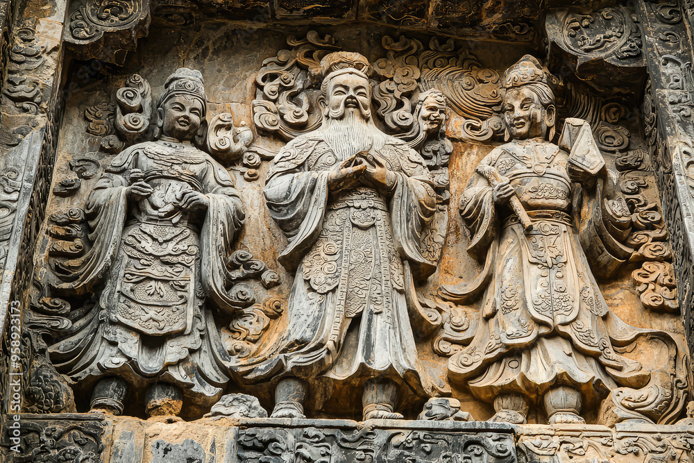 Obraz premium Intricate Stone Carvings Depicting Chinese Deities, a Testament to Ancient Artistic Mastery.