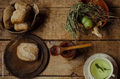 Hora del té: merienda rustica compuesta de té de hierbas, mermelada casera y pan integral en un ambiente calido y hogareño