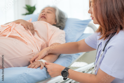 Asian female nurse gives saline solution to senior woman patient