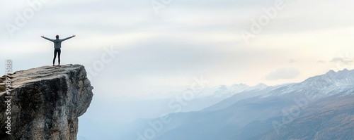 Person standing at the edge of a cliff with arms outstretched, ready for a new beginning