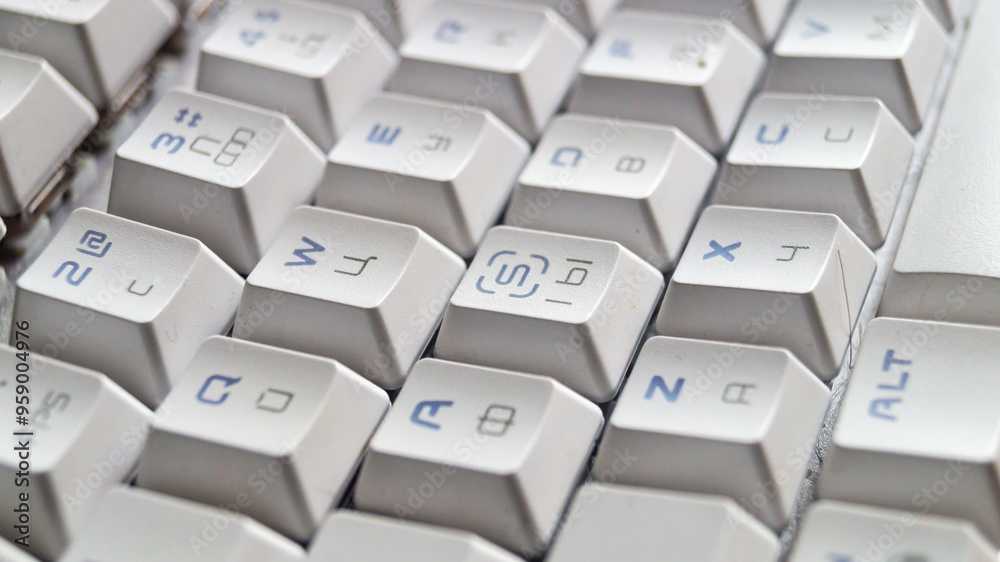 White mechanical keyboard with engraving of different languages on the keys White mechanical keyboard with engraving of different languages on the keys