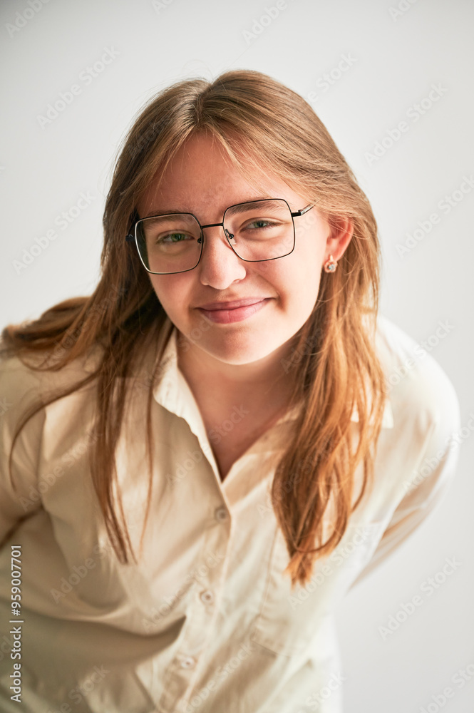 Portrait of beautiful girl smiling to camera. Cute girl in cream shirt and square glasses posing on white background. Portrait of beautiful girl smiling to camera. Cute girl in cream shirt and square glasses posing on white background.
