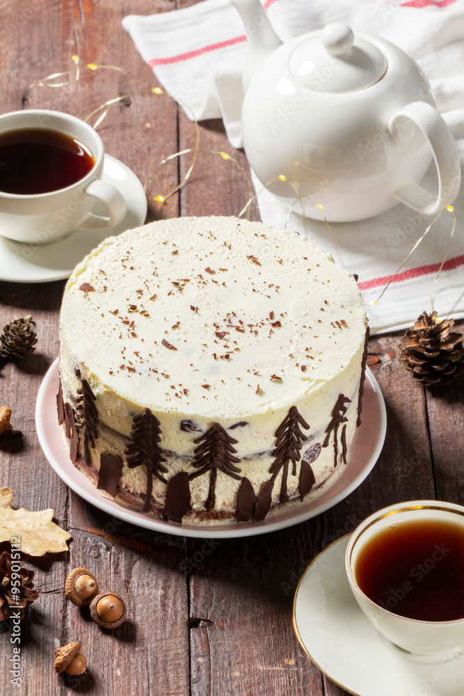 Tea party with Black Forest cake. Cherry cake decorated with chocolate fir trees on a light background.