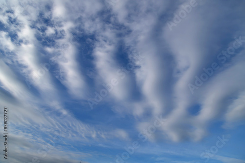 White cumulus clouds on a clear blue sky.