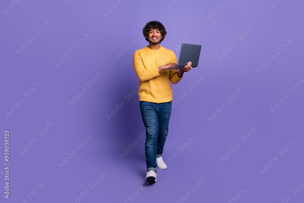 Photo of cheerful positive man wear stylish yellow clothes hold modern device isolated on purple color background Photo of cheerful positive man wear stylish yellow clothes hold modern device isolated on purple color background