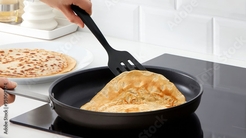 Closeup of a person flipping pancakes in a frying pan. photo