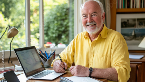 Focused man working on a laptop in a library with bookshelves behind him