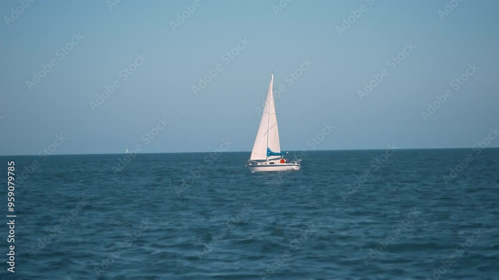 a slow-motion, cinematic shot of a sailboat gracefully gliding on a calm sea during sunset. The sailboat, with its tall mast and sleek white hull, stands out against the tranquil waters. The horizon a slow-motion, cinematic shot of a sailboat gracefully gliding on a calm sea during sunset. The sailboat, with its tall mast and sleek white hull, stands out against the tranquil waters. The horizon
