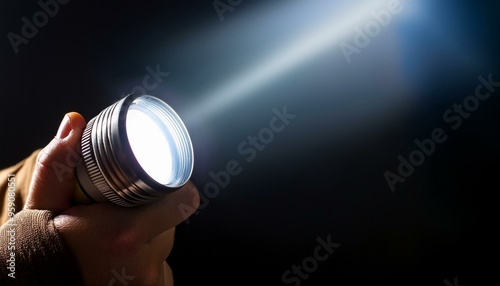 Holding a flashlight in the darkness, illuminating