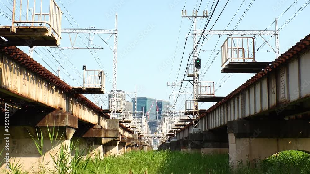 OSAKA, JAPAN - JUNE 2024 : View of train passing at Juso Ohashi bridge and buildings around Osaka station. Time lapse shot in daytime.