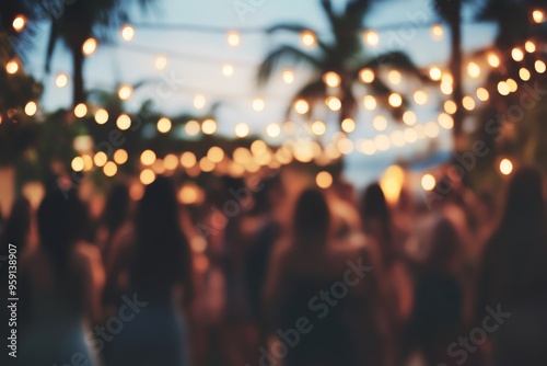 Outdoor evening celebration with string lights and blurred crowd under palm trees