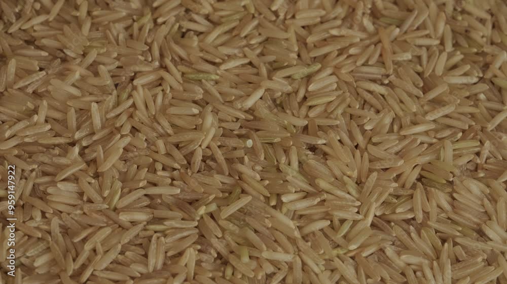 Uncooked brown basmati wholegrain rice background rotating macro. Asian food. Healthy eating concept Uncooked brown basmati wholegrain rice background rotating macro. Asian food. Healthy eating concept