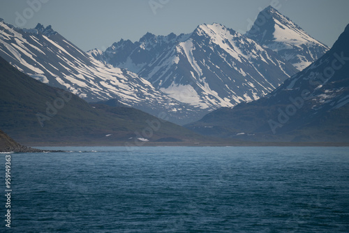 A bay surrounded by snow-capped mountains and dotted with ice formations. The magic of nature in its frozen splendor. A unique combination of ice and sea.Travel in cold weather, fresh air