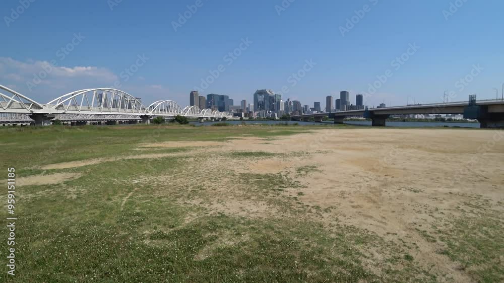 OSAKA, JAPAN - JUNE 2024 : View of buildings around Osaka station, bridge and Yodogawa river. Time lapse shot in sunny daytime. OSAKA, JAPAN - JUNE 2024 : View of buildings around Osaka station, bridge and Yodogawa river. Time lapse shot in sunny daytime.