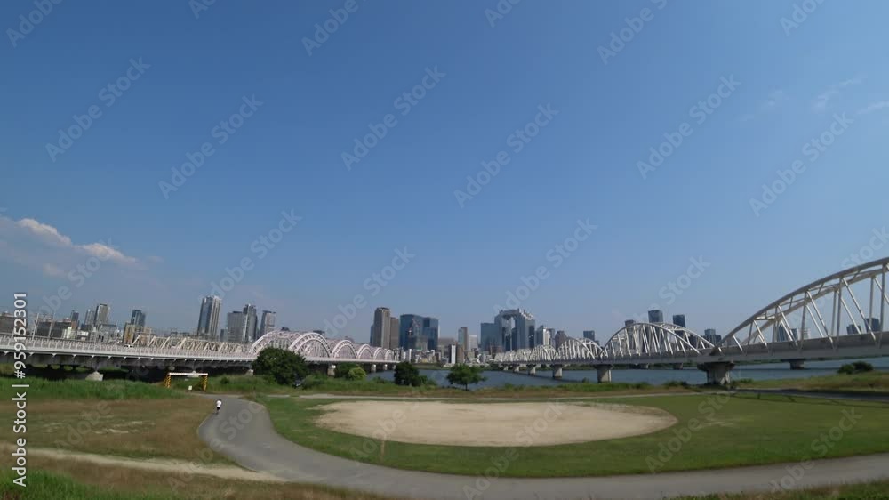 OSAKA, JAPAN - JUNE 2024 : View of buildings around Osaka station, bridge and Yodogawa river. Time lapse shot in sunny daytime. OSAKA, JAPAN - JUNE 2024 : View of buildings around Osaka station, bridge and Yodogawa river. Time lapse shot in sunny daytime.