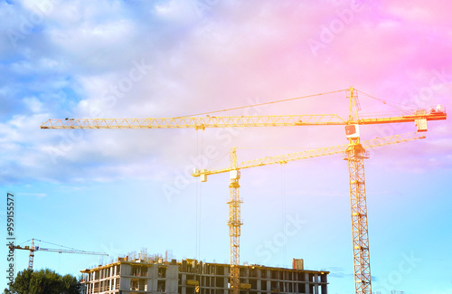 Construction site with jib cranes. Construction of Residential Building. Tower Crane on formworks. House Construction. Tower Cranes on Residential buildings Construction on blue sky background.