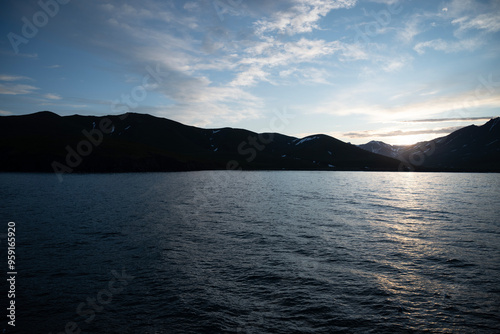 Stunning sunset over mountains and sea on wild natural islands in the northern region of the world, a journey to the cold and fiery sunsets of nature