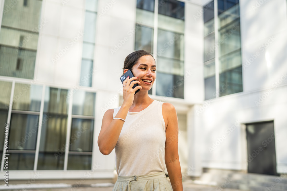 Portrait of young woman talk on mobile phone in front building