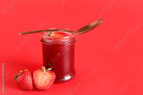 Jar with sweet strawberry jam on red background photo