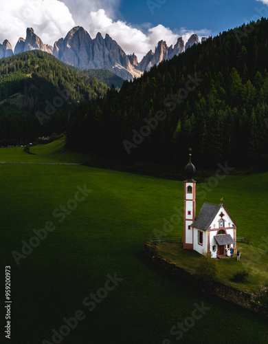 Vista aérea de la iglesia de San Juan (Chiesetta di San Giovanni in Ranui) en el Tirol del Sur con las montañas al fondo. Val di Funes (Dolomitas, Italia) photo