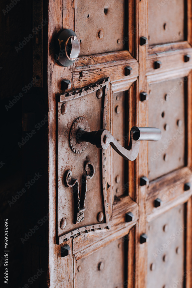 Medieval handle with lock made of wrought iron on wooden doors Medieval handle with lock made of wrought iron on wooden doors
