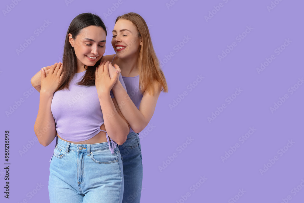 Beautiful young lesbian couple on lilac background Beautiful young lesbian couple on lilac background