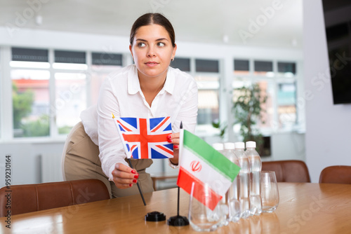 Secretary shows the flags of Britain and Iran on the table. Preparing for a meeting, negotiations. photo