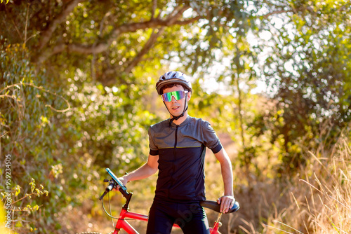 A cyclist takes a break on his mountain bike trail. The forest background create a serene outdoor atmosphere, perfect for an active lifestyle.