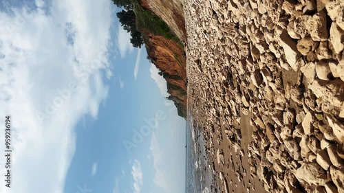 View of the steep bank of the Volga River, covered with pebbles, in the distance of which an ancient Orthodox Church can be seen standing on a hill. photo