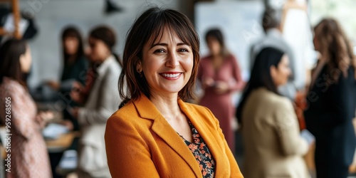 Smiling Woman in an Orange Blazer at a Business Networking Event