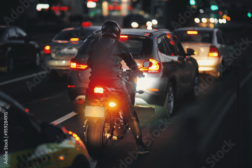 Wallpaper Mural Motorbike rider waits in heavy evening traffic, vehicles on busy road with glowing headlights, ambient lights of the city. Night riding. Motorcyclist in full gear navigating crowded street at dusk Torontodigital.ca
