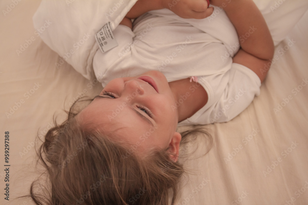 the little girl playing and tickling on the bed and having fun