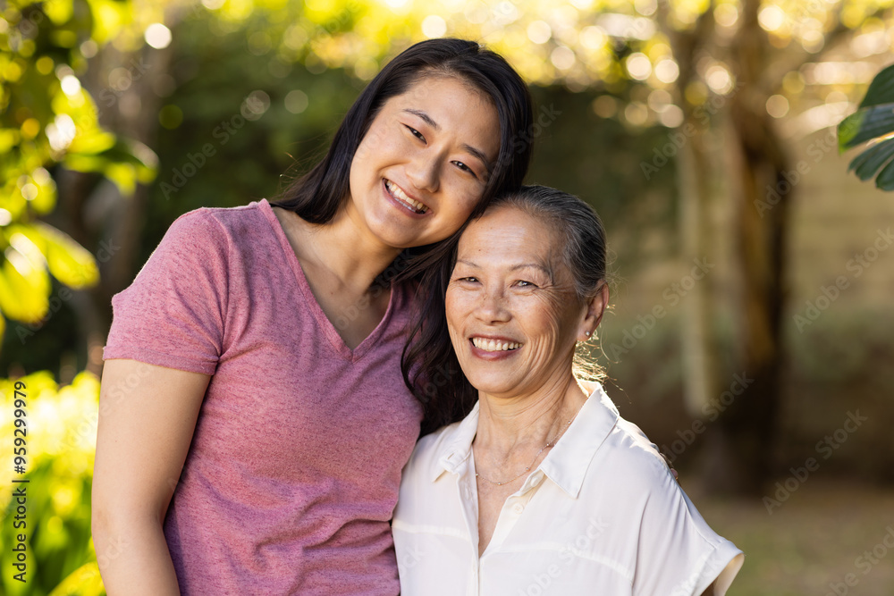 Smiling granddaughter and asian grandmother posing together outdoors, enjoying time Smiling granddaughter and asian grandmother posing together outdoors, enjoying time