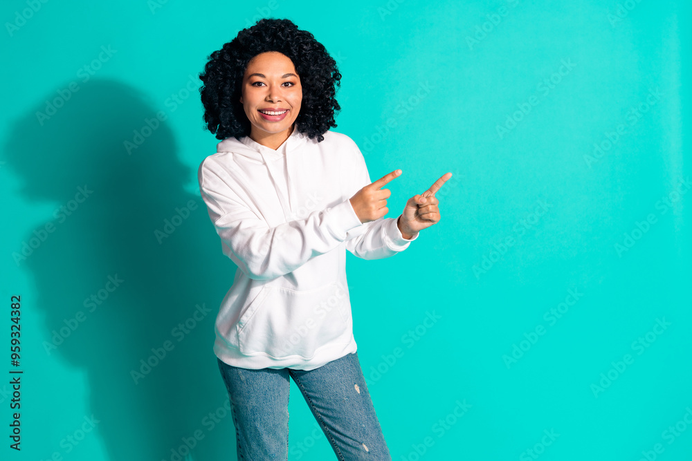 Photo portrait of young funny chevelure hairstyle lady wearing white hoodie point fingers empty blank space isolated on cyan color background Photo portrait of young funny chevelure hairstyle lady wearing white hoodie point fingers empty blank space isolated on cyan color background