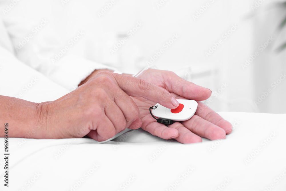 Senior woman pressing emergency call button on bed in hospital, closeup Senior woman pressing emergency call button on bed in hospital, closeup