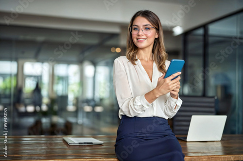 Happy mature business woman executive holding cell phone looking away in office. Smiling professional businesswoman manager entrepreneur using cellphone working on smartphone.