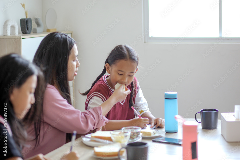 Mother Feeding Daughter While Doing Homework Mother Feeding Daughter While Doing Homework