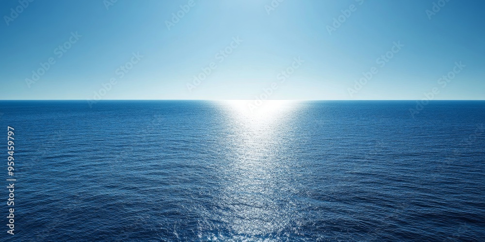 Obraz premium A bright blue sky and a vast expanse of sparkling blue ocean with a sliver of sunlight reflecting on the water.