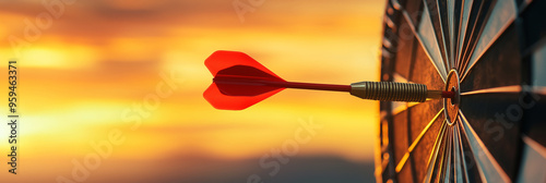 Close up red dart arrow hitting target center dartboard on sunset background. Business targeting and focus concept
