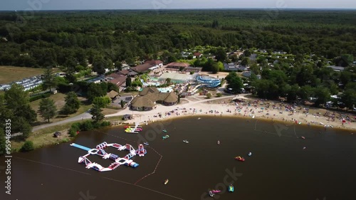 Drone Footage Starts Highs Over a Campsite Lake and Flies Down and towards the Restuarant, Swimming Pool, Playground, and Water Park. France.