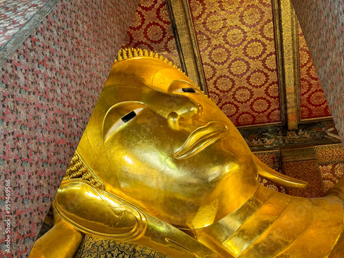 The famous Reclining Buddha statue in Wat Pho Temple, Bangkok, Thailand. Reclining Buddha inside Wat Pho made of gold materials.