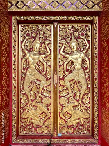 Close up of Thailand Buddhist temple engraving and mural art pattern on doors, carved in every details, mainly in red and gold colors. Grand luxurious religious feel. Seamless background texture. 